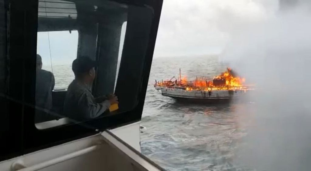 Petugas Badan Keamanan Laut di Kapal Negara (KN) Pulau Dana-323 berupaya memadamkan Kapal Motor Bintang Surya yang terbakar di perairan Karimun, Kepulauan Riau, Minggu (12/6/2022).