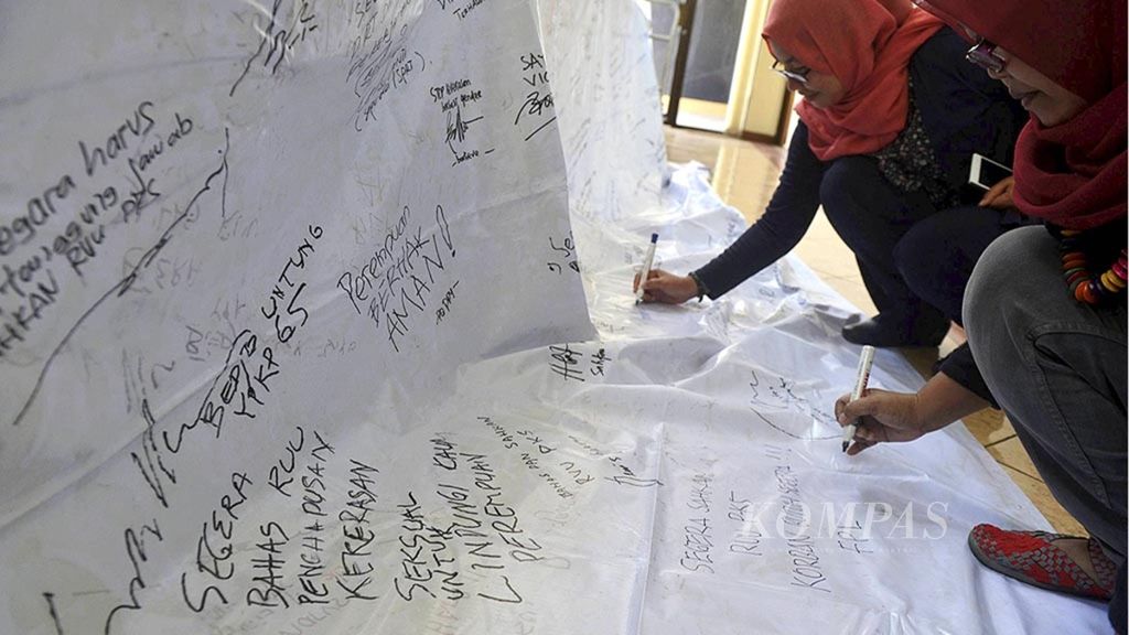 Aktivis perempuan menuliskan pesan untuk mendesak DPR agar segera mengesahkan RUU Penghapusan Kekerasan Seksual saat berlangsung paparan catatan LBH Apik tentang penanganan kasus kekerasan terhadap perempuan di Kantor Komnas Perempuan, Jakarta, 20 Juli 2017. 