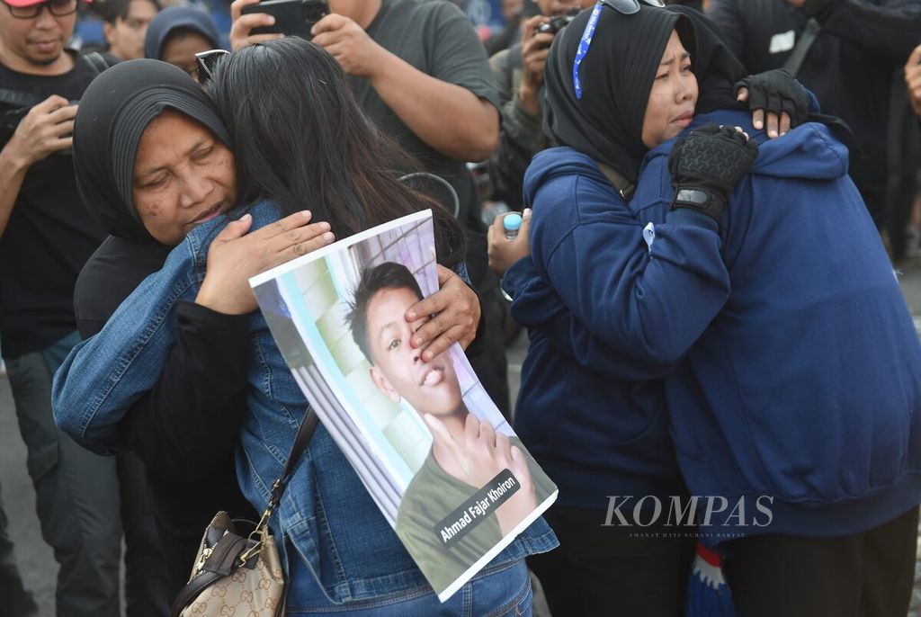 Keluarga korban menangis saat peringatan satu tahun tragedi Kanjuruhan di Stadion Kanjuruhan, Kabupaten Malang, Jawa Timur, Minggu (1/10/2023). Kekecewaan akan penanganan kasus masih disuarakan dalam peringatan tragedi yang merenggut 135 nyawa tersebut.