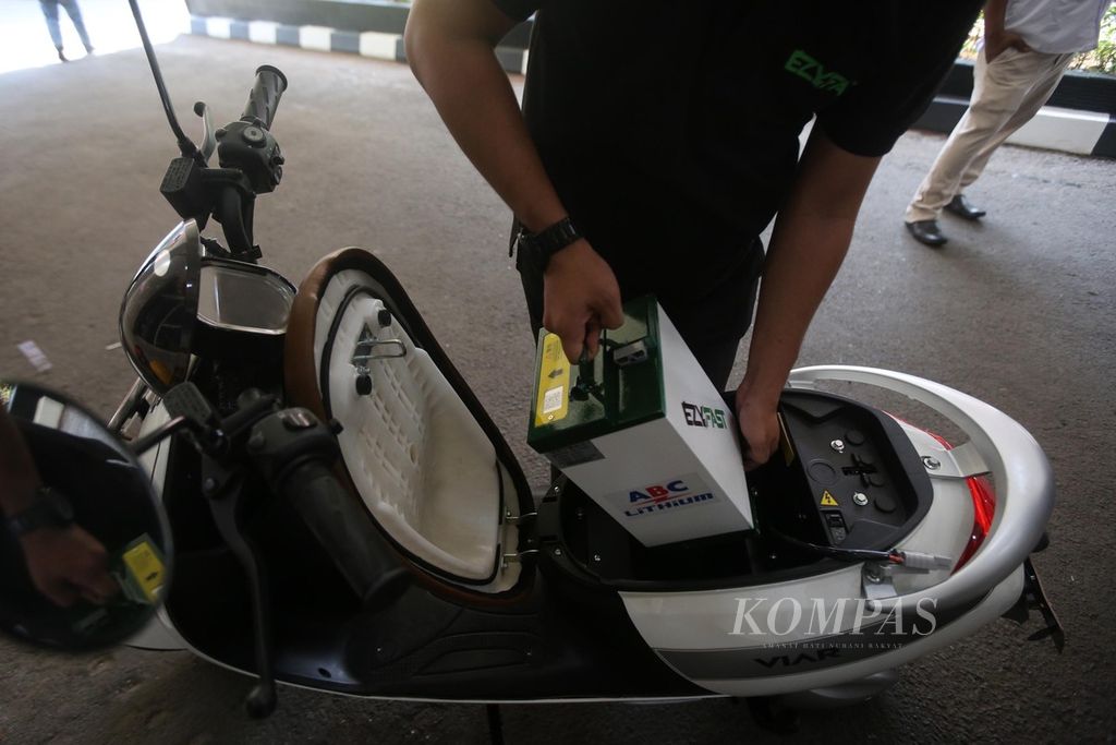 Petugas melepas baterai motor listrik saat uji coba stasiun penukaran baterai kendaraan listrik umum (SPBKLU) di Jakarta, Senin (31/8/2020). 