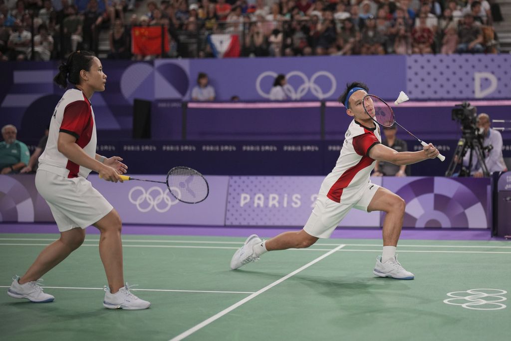 Aksi ganda campuran Indonesia, Rinov Rivaldy/Pitha Haningtyas Mentari, melawan ganda campuran nomor satu dunia, Zheng Si Wei/Huang Ya Qiong, pada penyisihan grup bulu tangkis Olimpiade Paris 2024 di Porte de la Chapelle Arena, Paris, Perancis, Minggu (28/7/2024).