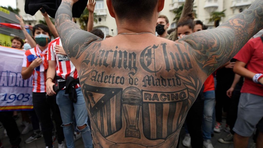 周日（2021 年 5 月 23 日），在西班牙马德里的海王星环形交叉路口，皇家马德里队击败巴拉多利德队，夺得 2020-2021 赛季西班牙联赛冠军，一名皇家马德里球迷在欢迎他引以为豪的球队回家时展示了一幅描绘西班牙联赛奖杯的纹身。