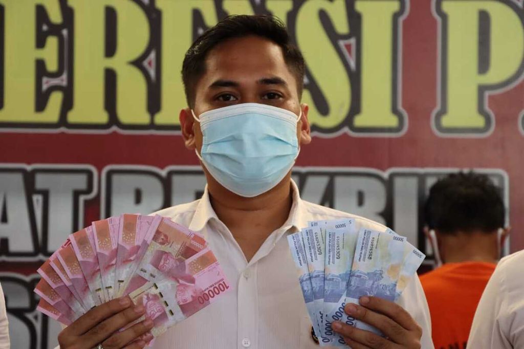 Penyidik Polresta Banda Aceh, Provinsi Aceh, memperlihatkan uang palsu yang disita dari tersangka NF dan YYM, Senin (25/4/2022). Menjelang Lebaran, peredaran uang palsu lebih masif. Pedagang dan pembeli diminta untuk lebih teliti saat melakukan transaksi jual beli