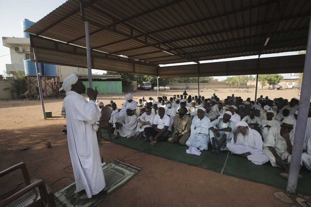 People attend Eid al-Firtr prayer in Khartoum, Sudan, Friday, April 21, 2023. Eid al-Fitr holiday, that marks the end of the holy Islamic month of Ramadan, is marked by faithful as gunshots rang out across the capital of Khartoum and heavy smoke billowed over the skyline.