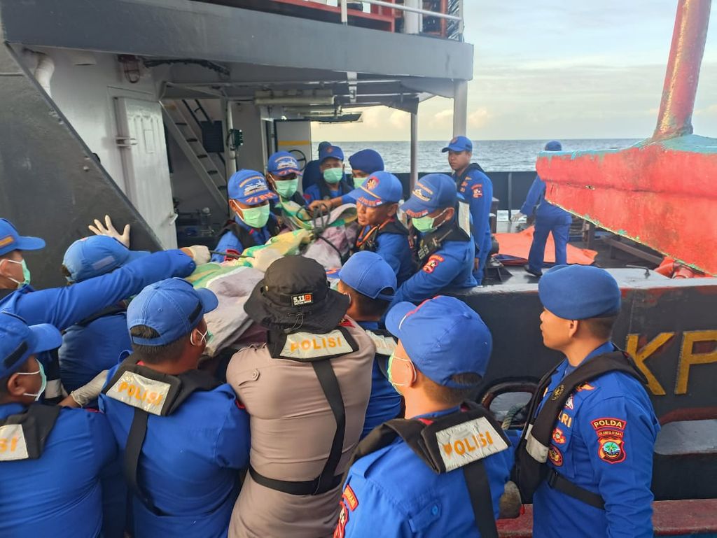 Petugas kepolisian mengevakuasi jenazah korban LCT Bora V di perairan Tagulandang, Sulawesi Utara, Senin (22/1/2024). Sebanyak 10 penumpang selamat, 2 meninggal, dan 6 lainnya hilang.