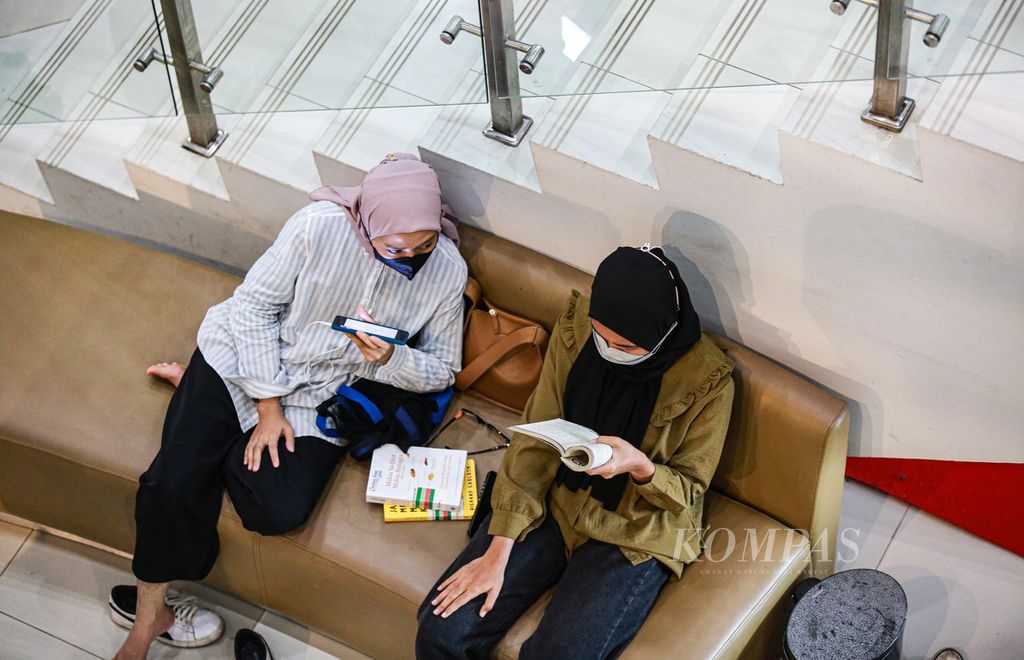 Pengunjung remaja menikmati buku bacaan di Perpustakaan Nasional Jakarta, Jumat (27/5/2022).