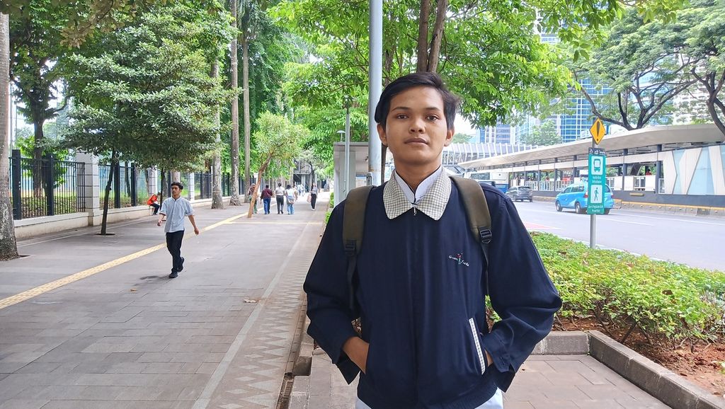 Revan Herdiawan (22), baru tiba di kawasan Senayan dari rumahnya di Lenteng Agung, Jakarta Selatan, menuju ke restoran tempatnya bekerja, Senin (26/2/2024).