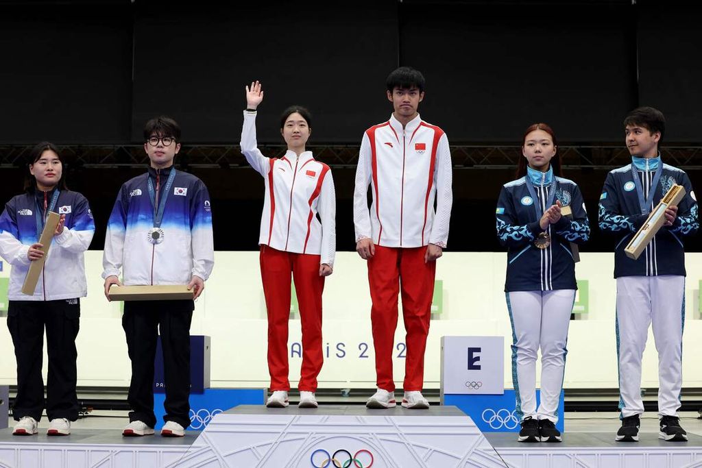 Peraih medali emas, Yuting Huang dan Lihao Sheng asal China, berdiri di podium saat acara penyerahan medali Olimpiade Paris 2024, Sabtu (27/7/2024). Huang dan Sheng menjadi peraih emas pertama di Paris dari menembak nomor 10 meter <i>air rifle</i>.