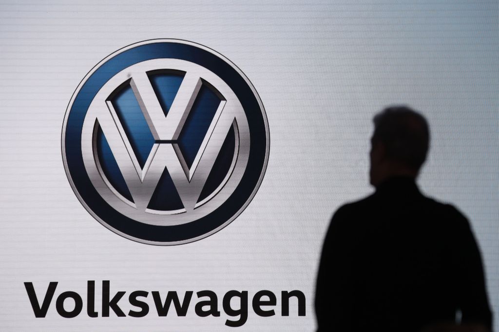 Foto yang diambil pada 28 November 2018 memperlihatkan seorang laki-laki berdiri di samping logo produsen otomotif asal Jerman, Volkswagen, yang tengah mengikuti pameran otomotif Los Angeles Auto Show di LA, Amerika Serikat.  