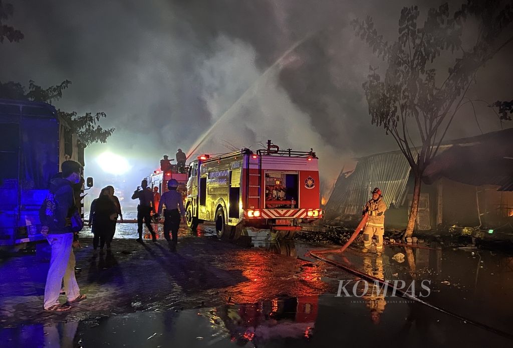 Warga melihat kebakaran di relokasi Pasar Johar di kawasan Masjid Agung Jawa Tengah, Kecamatan Gayamsari, Kota Semarang, Rabu (2/2/2022). Penyebab kebakaran masih diselidiki.