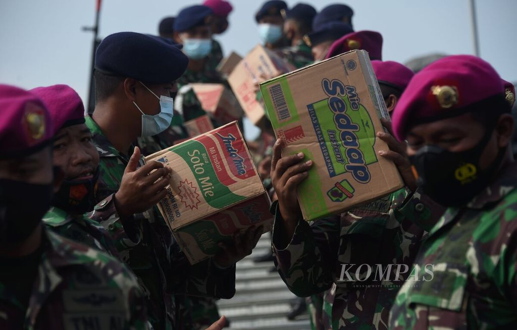 Anggota TNI AL memindahkan bantuan bencana alam ke KRI Oswald Siahaan yang akan bertolak ke Mamuju, Sulawesi Barat, Dermaga Armada II, Surabaya, Jawa Timur, Kamis (21/1/2021). 