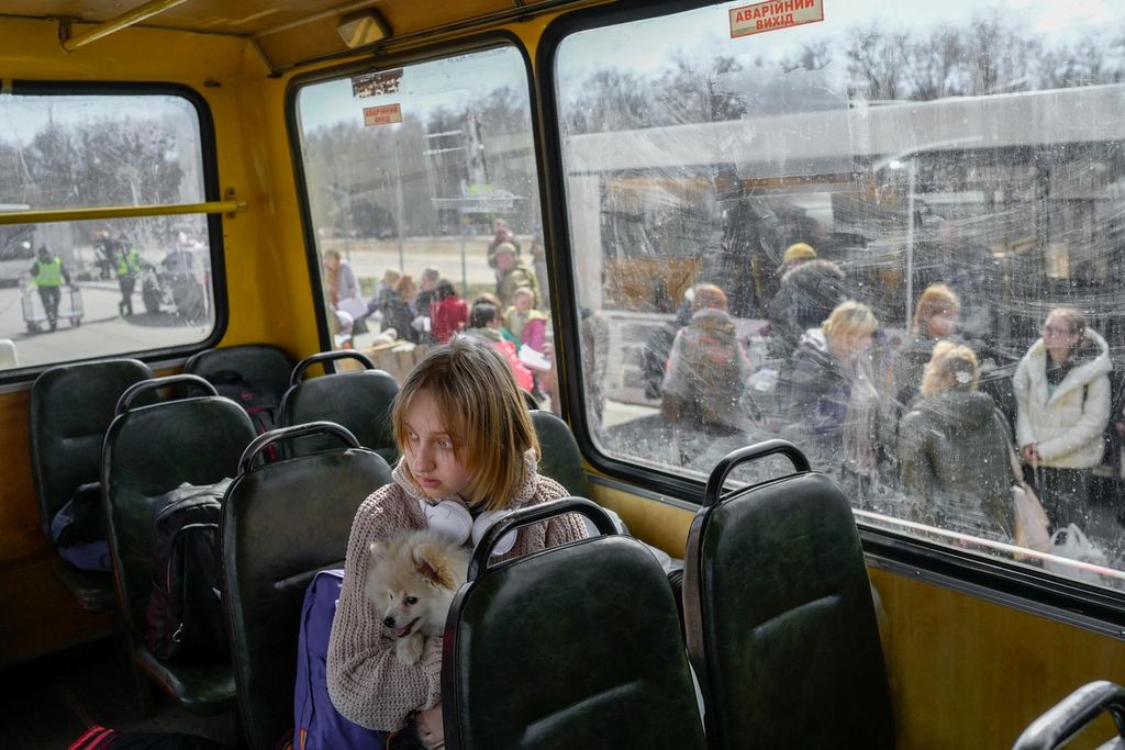Seorang perempuan muda dan anjingnya tiba di pusat pengungsian dalam negeri di Zaporizhzhia, sekitar 200 kilometer barat daya Mariupol, Ukraina, 6 April 2022. 