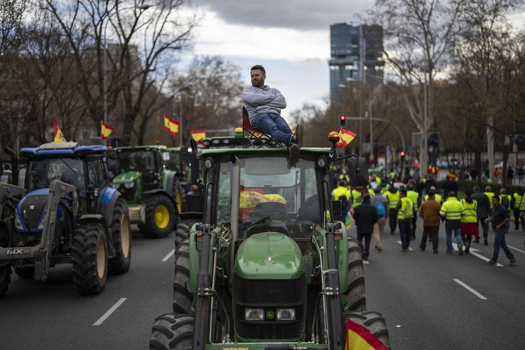 Seorang petani duduk bertengger di atas traktor dalam unjuk rasa petani di luar kantor Parlemen Eropa di Madrid, Spanyol, 26 Februari 2024. 