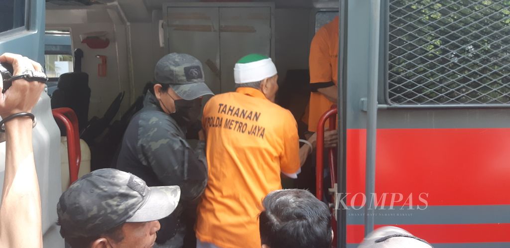Salah satu tersangka dari organisasi Khilafatul Muslimin digiring polisi ke dalam kendaraan taktis di Polda Metro Jaya, Jakarta, Senin (3/10/2022). Mobil itu akan mengantarkan mereka ke Kejaksaan Negeri Bekasi.