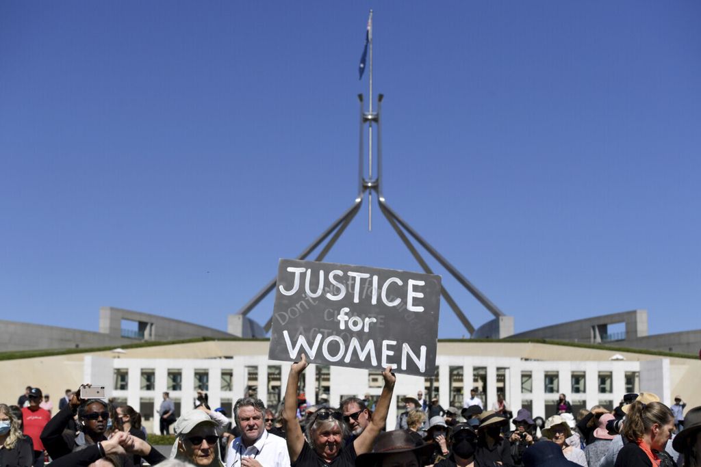Pengunjuk rasa mengangkat poster saat peringatan Women’s March 4 Justice di Canberra, Australia, 15 Maret 2021. Unjuk rasa memprotes seksisme, misogini, dan tempat kerja yang berbahaya bagi perempuan. 