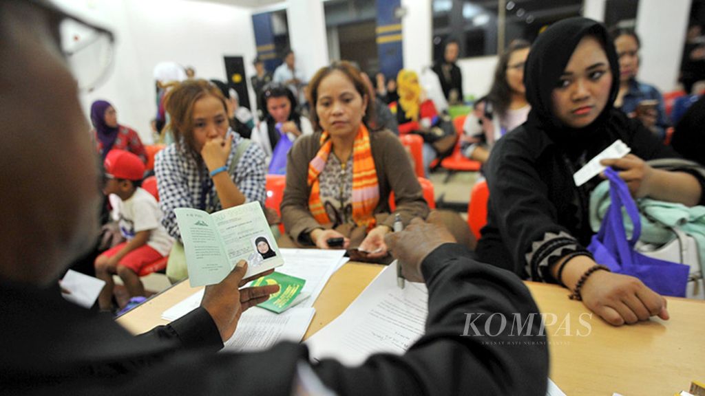Petugas Badan Nasional Penempatan dan Perlindungan Tenaga Kerja Indonesia memverifikasi data WNI yang baru tiba dari Arab Saudi di Bandara Internasional Soekarno-Hatta, Tangerang, Banten, Sabtu (10/6). 