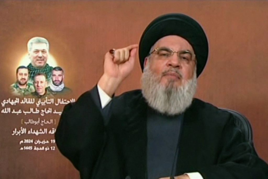 Foto tangkapan layar televisi Al-Manar pada 19 Juni 2024 ini memperlihatkan Pemimpin Hezbollah Hassan Nasrallah berpidato melalui televisi dari sebuah lokasi yang tidak disebutkan di Lebanon. 