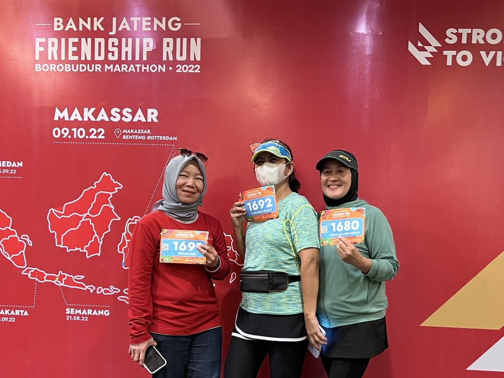 Erna Kacici (51, baju merah) berfoto bersama rekannya dari komunitas Run for Indonesia seusai mengambil <i>race pack</i> di Hotel Santika Makassar, Sabtu (8/10/2022).