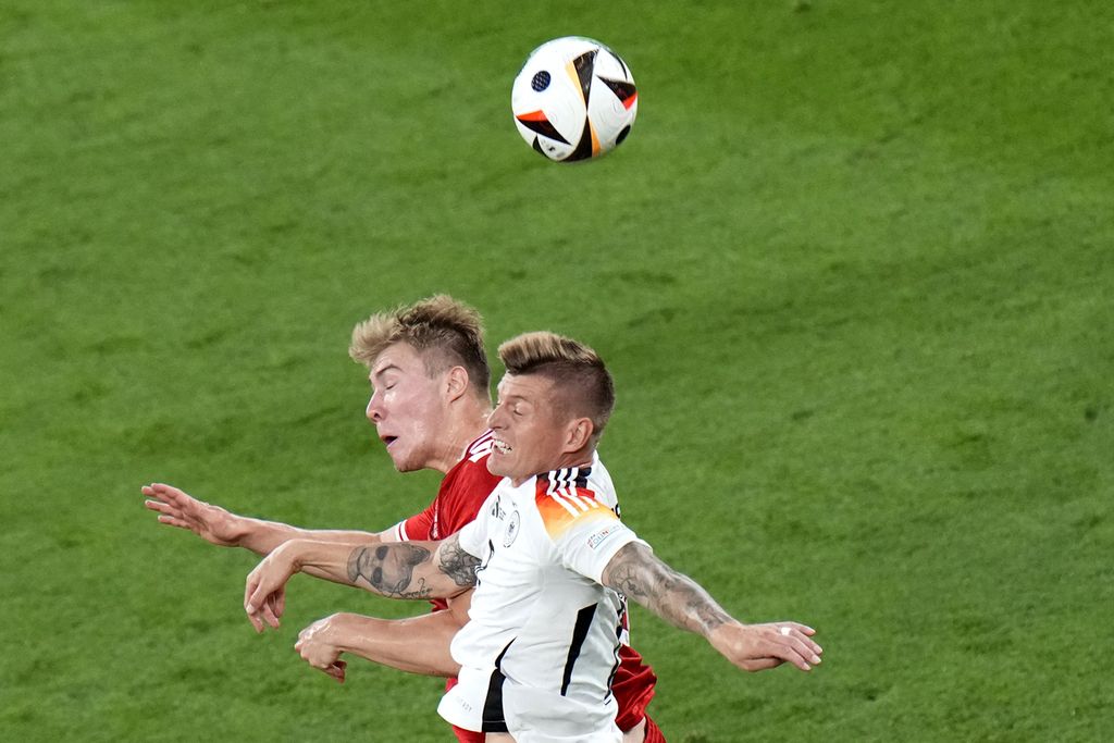 Gelandang Jerman, Toni Kroos, berebut bola dengan penyerang Denmark, Rasmus Hojlund, dalam pertandingan babak 16 besar Piala Eropa 2024 di Dortmund, Jerman, Minggu (30/6/2024) dini hari WIB.