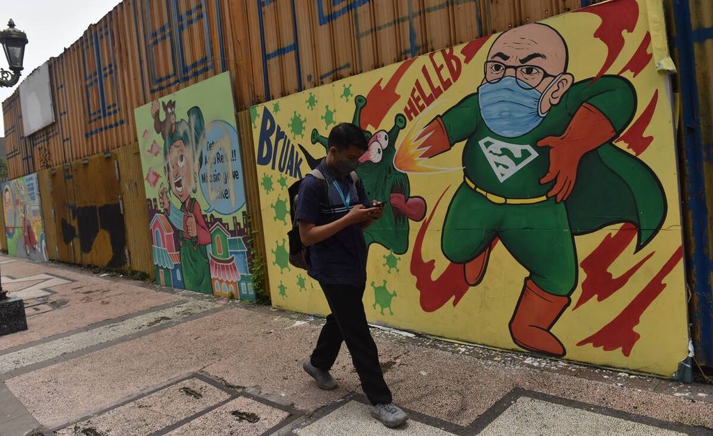 Warga melintas di depan mural bertema protokol kesehatan di Jalan Tunjungan, Kota Surabaya, Jawa Timur, Senin (21/2/2022). Mural yang sejatinya untuk mengingatkan warga untuk patuh pada protokol kesehatan banyak dirusak oleh tangan yang tidak bertanggung jawab.