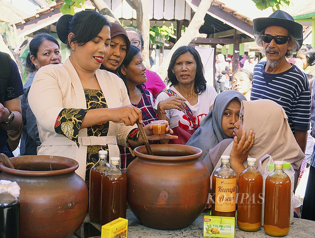 Peserta Festival Minum Jamu membagikan jamu kunyit asam kepada pengunjung Plaza Pasar Ngasem, Yogyakarta,  Sabtu (17/2). Festival ini menjadi sarana promosi bagi industri jamu tradisional Tanah Air untuk lebih dikenal di kalangan masyarakat luas.