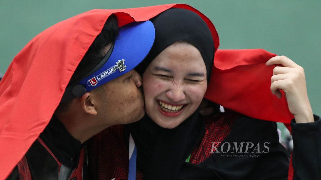  Indonesian shooting athlete Fathur Gustafian kisses his girlfriend who is also a female athlete shooting Dewi Laila Mubarokah when he won the final number 10 meter individual air rifle for the men's shooting branch of the SEA Games Vietnam 2021 at the Sport Training Center Hanoi, Hanoi, Vietnam, Tuesday (17/5/2022).