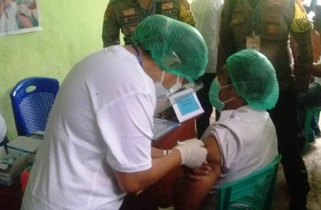 Salah seorang tenaga kesehatan di Puskesmas Nita, Sikka, NTT,  mendapatkan vaksin dari vaksinator Dinas Kesehatan Sikka, Februari 2021.  