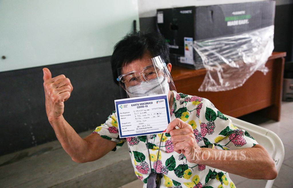 Seorang lansia dengan bangga memperlihatkan kartu vaksinnya setelah menerima suntikan vaksin Covid-19 dosis pertama di Sekolah Cinta Kasih Tzu Chi, Cengkareng, Jakarta Barat, Rabu (24/2/2021). 
