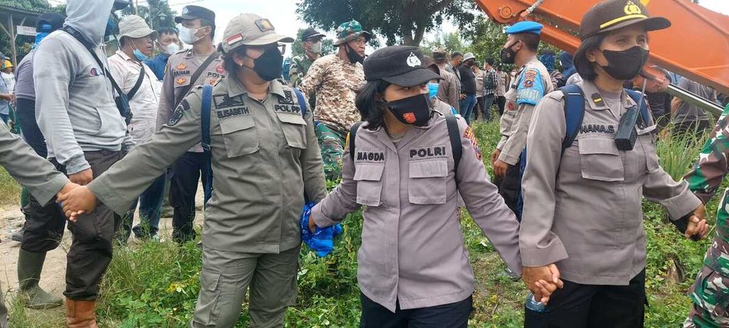 Petugas menjaga alat berat yang merobohkan rumah warga di lahan konflik masyarakat dengan PT Perkebunan Nusantara III di Kelurahan Gurilla, Kecamatan Siantar Sitalasari, Kota Pematang Siantar, Sumatera Utara, Jumat (25/11/2022).