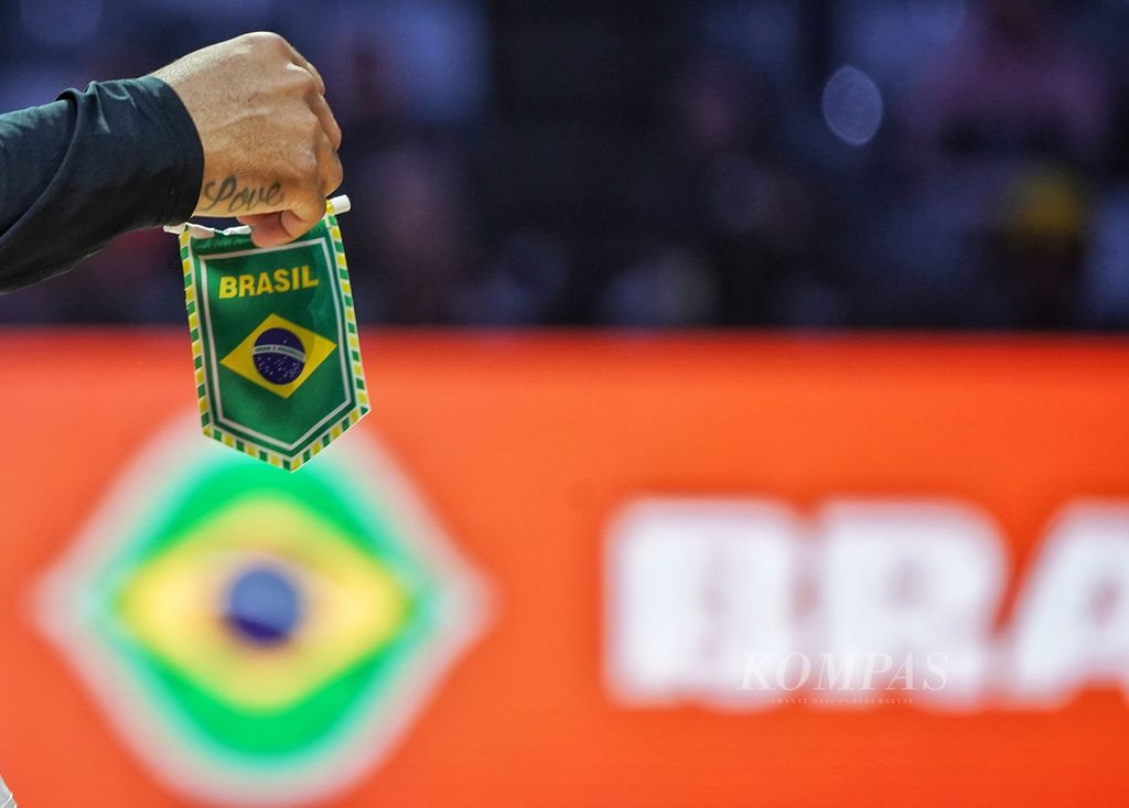 <i>Guard </i>tim Brasil, Yago Santos, memegang cendera mata bermotif bendera Brasil untuk tim Latvia jelang laga penutup babak kedua Piala Dunia FIBA 2023 di Stadion Indonesia Arena, Jakarta, Minggu (3/9/2023). 