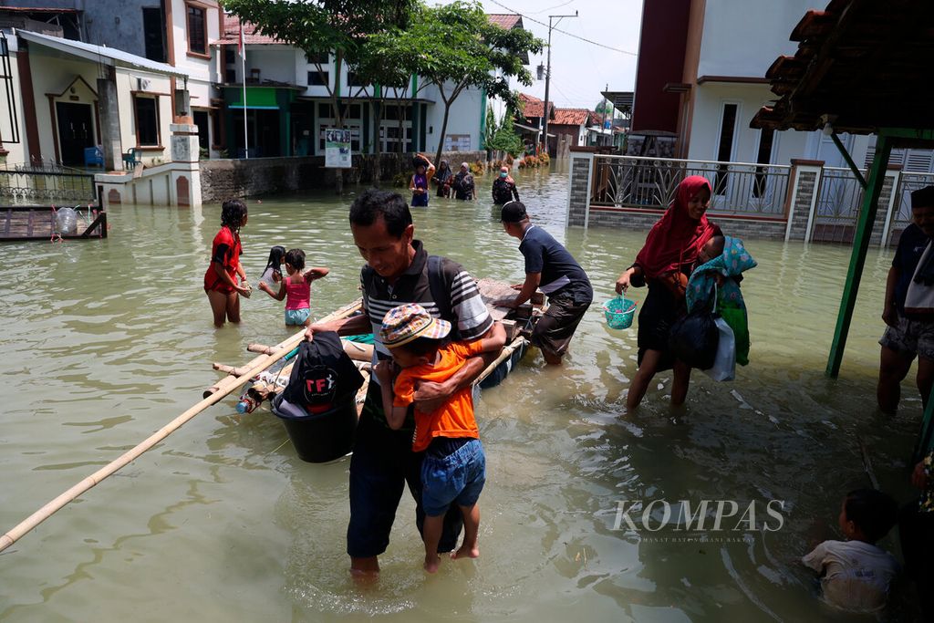 Warga turun dari sampan yang mengantarkan mereka ke pengungsian di Desa Wonoketingal, Kecamatan Karanganyar, Kabupaten Demak, Jawa Tengah, Selasa (19/3/2024).
