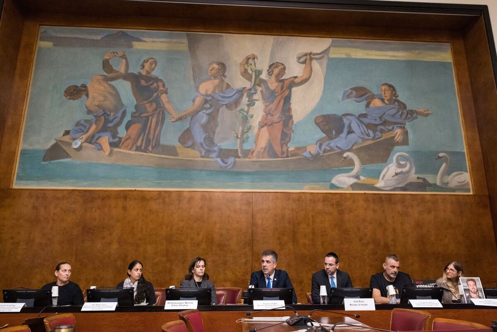 Menteri Luar Negeri Israel  Eli Cohen (tengah) dan Menteri Kesehatan Israel Uriel Buso (ketiga dari kanan) duduk di dekat keluarga korban tawanan Gaza di Markas Besar PBB di Geneva, Swiss, 14 November 2023.  