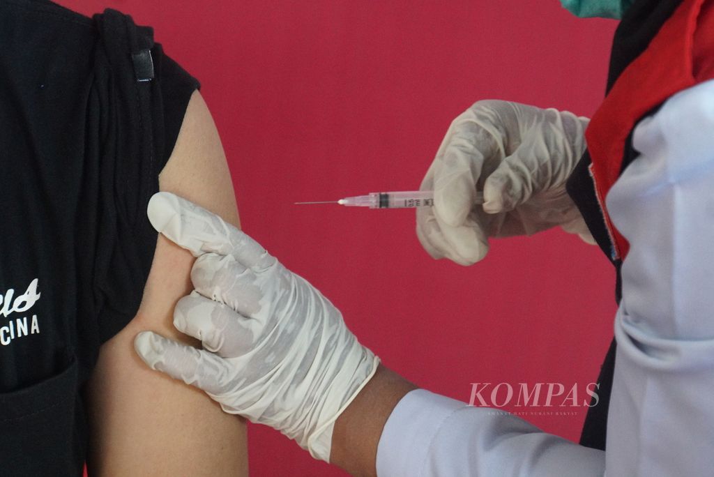 Petugas vaksinasi bersiap menyuntikkan vaksin CoronaVac bervolume 0,5 mililiter ke lengan penerima, Jumat (15/1/2021) di Rumah Sakit Darurat Lapangan Kitawaya, Manado, Sulawesi Utara. Sulawesi Utara mendapatkan 23.760 dosis vaksin untuk tahap pertama vaksinasi Covid-19 bagi tenaga kesehatan.