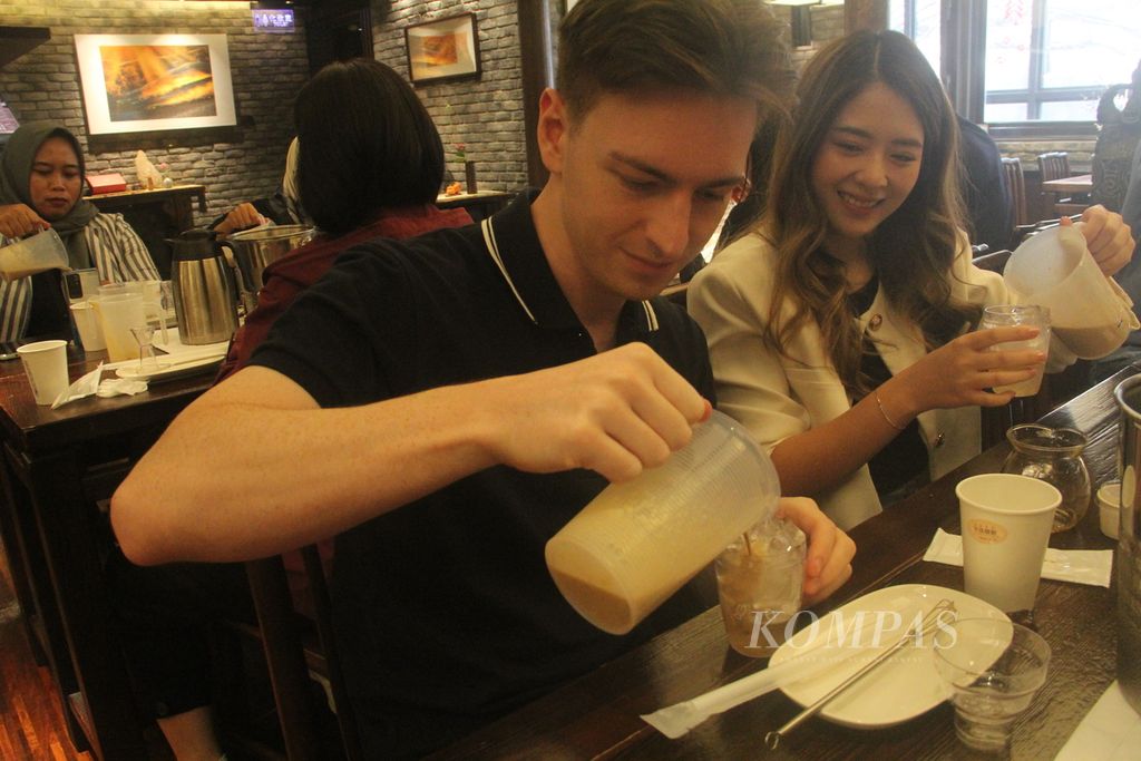 Wisatawan mempraktikkan cara membuat minuman <i>bubble tea</i>, Jumat (23/2/2024), di restoran Chun Shui Tang, kota Taichung, Taiwan. 
