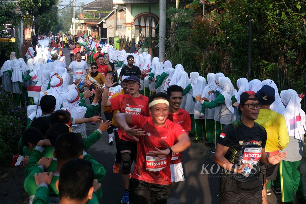 Siswa sekolah menampilkan atraksi untuk memberikan semangat kepada pelari Tilik Candi Borobudur Marathon 2022 Powered by Bank Jateng di Magelang, Jawa Tengah, Minggu (12/11/2022). Sebanyak 4.552 pelari mengikuti lomba lari dengan jarak 21.097 kilometer atau separuh maraton. 