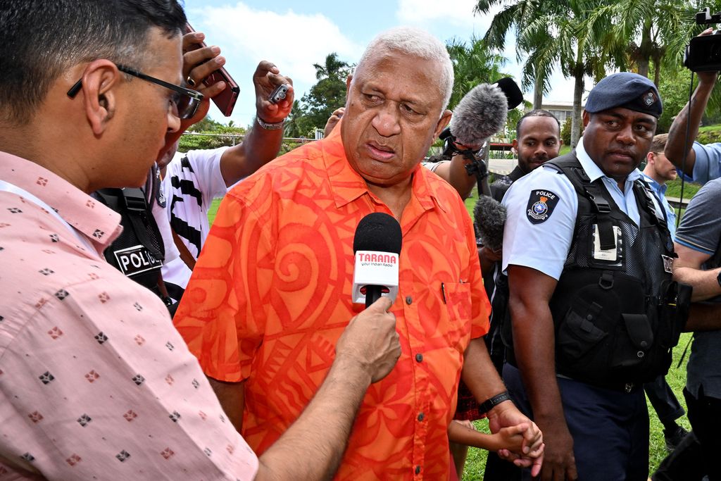 Perdana Menteri Fiji Frank Bainimarama tengah mendengarkan pertanyaan jurnalis ketika hendak menggunakan hak pilihnya di di Sekolah Yat Sen di Ibu Kota Suva, Fiji, Rabu (14/12/2022). Bainimarama untuk ketiga kalinya mencalonkan diri sebagai PM. (Photo by SAEED KHAN / AFP) 