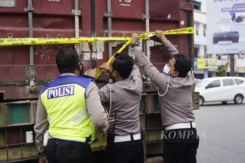Polisi memasang garis polisi pada truk kontainer yang menabrak belasan kencaraan dalam kecelakaan di simpang Muara Rapak, Kecamatan Balikpapan Utara, Kota Balikpapan, Kalimantan Timur, Jumat (21/1/2022). Sebanyak 4 korban meninggal, 4 luka parah, dan 26 luka ringan.