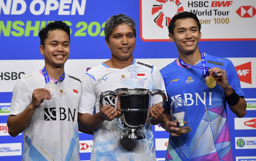 Indonesian badminton players, Anthony Sinisuka Ginting (left) and Jonatan Christie (right), pose with their coach, Irwansyah (center), after competing in the men's singles final at the All England in Arena Birmingham, England, on Sunday (17/3/2024).