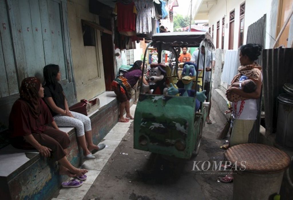 Tukang odong-odong melintas di salah satu gang sempit di Kawasan Cipulir, Jakarta Selatan, Senin (27/8/2012). Banyaknya pendatang membuat kawasan tersebut banyak didirikan rumah kontrakan murah. Sebagian besar warga pendatang bekerja sebagai pedagang di Pasar Kebayoran Lama.