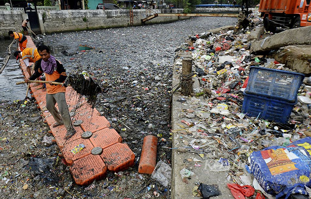 Pekerja harian lepas dari UPK Badan Air DKI Jakarta memisahkan sampah-sampah plastik yang memenuhi Kali Sentiong, Kemayoran, Jakarta Pusat, Selasa (12/9). Perilaku masyarakat yang membuang sampah sembarangan tidak hanya mencemari sungai, tetapi juga dapat berdampak mencemari laut karena sampah terbawa ke muara sungai.