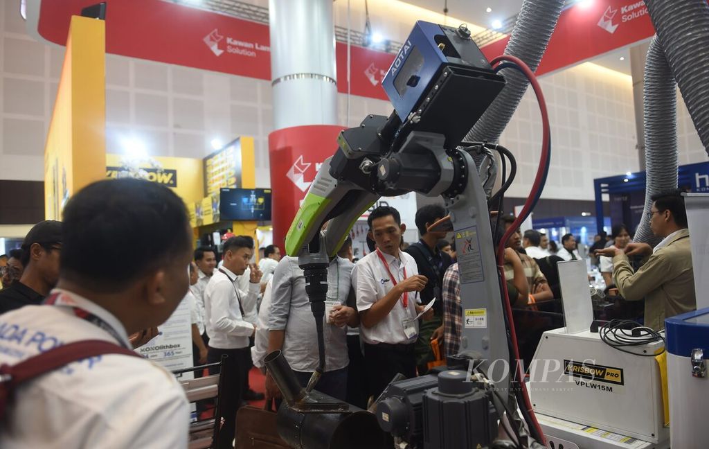 Pengunjung melihat robot pengelas bekerja di salah satu stan pameran Manufacturing Surabaya di Grand City Convention and Exhibition Center, Surabaya, Kamis (18/7/2024). Pameran digelar mulai 17 hingga 20 Juli 2024.