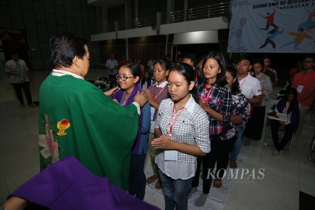 Uskup Surabaya Mgr Vincetius Sutikno Wisaksono memberi berkat dan mengalungkan selendang ungu kepada peserta kaderisasi pelajar Katolik SMA se-Keuskupan Surabaya.