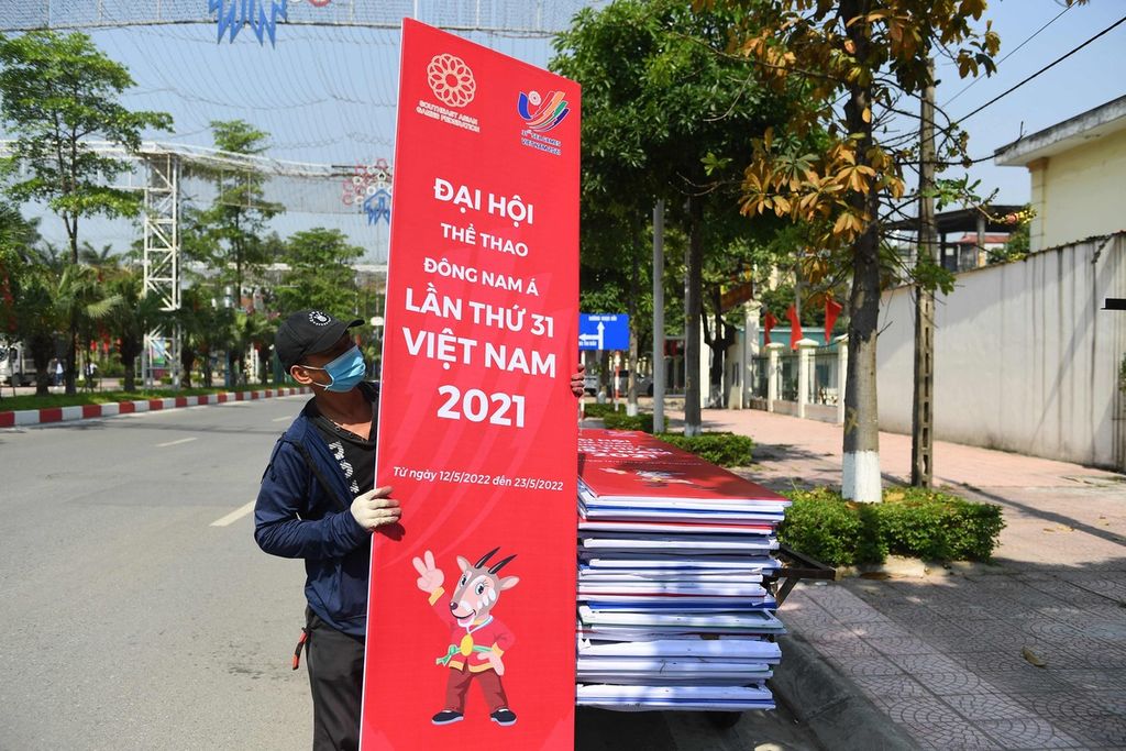 A worker carries a banner for the upcoming 31st Southeast Asian Games (SEA Games) in Hanoi on May 4, 2022, before the start of the multi-sport event on May 12. (Photo by Nhac NGUYEN / AFP)