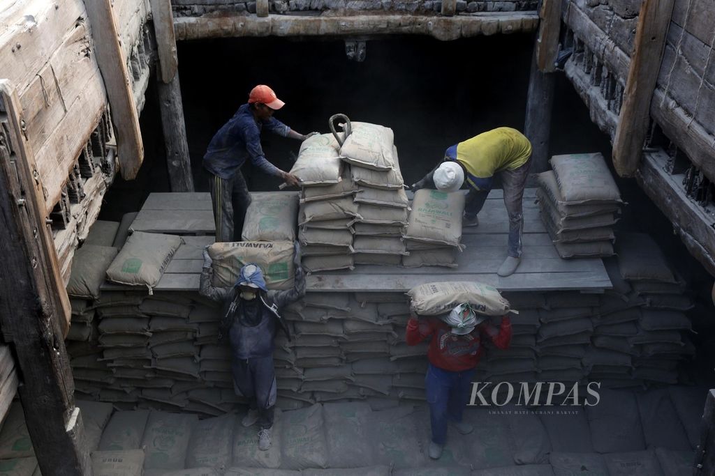 Buruh memindahkan semen ke dalam lambung kapal pinisi untuk dikirim ke Kalimantan, di Pelabuhan Sunda Kelapa, Jakarta, Rabu (8/11/2023). Masifnya proyek pembangunan infrastruktur pemerintah, termasuk pembangunan IKN, menyebabkan penjualan semen domestik tumbuh signifikan. 