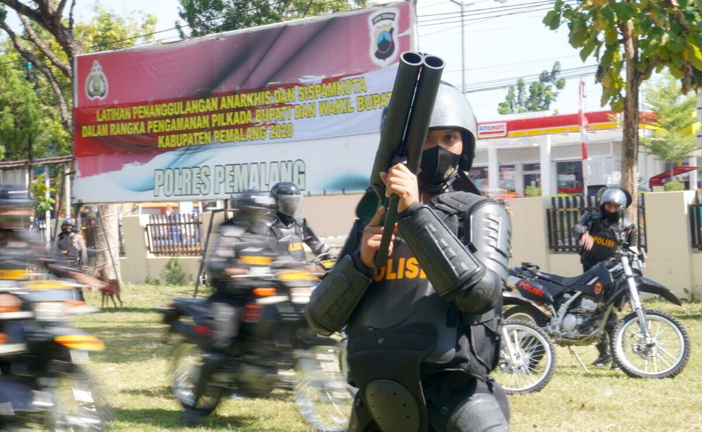 Suasana simulasi pengamanan pilkada digelar, Jumat (28/8/2020), di halaman Polres Pemalang, Jateng. Seorang polisi digambarkan bersiap menembakkan gas air mata ke arah massa aksi yang ricuh.