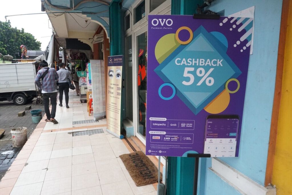 Sebuah kios memberikan <i>cashback </i>5 persen untuk transaksi menggunakan uang elektronik OVO.