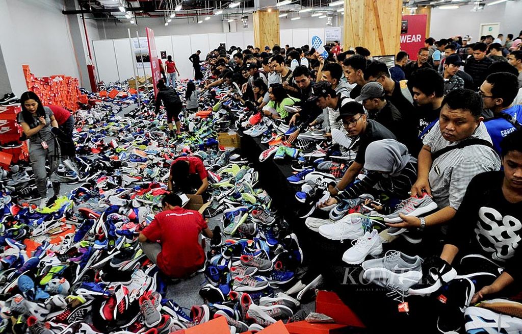 Pengunjung memilih sepatu  yang ditawarkan dengan potongan harga khusus dalam Nike Bazaar di Grand Indonesia, Jakarta, Rabu (23/8). Animo pengunjung yang tinggi membuat penyelenggara membatasi jumlah pengunjung yang masuk arena bazar. Antrean pengunjung menumpuk hingga area parkir kendaraan di lantai P 5.1.