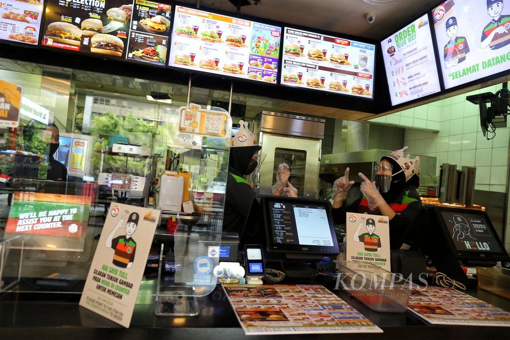 Teman tuli berbincang dengan rekannya melalui gerakan isyarat sembari menunggu pelanggan di restoran cepat saji Burger King di Thamrin, Jakarta, Kamis (3/12/2020). Saat ini Burger King telah merekrut 100 teman tuli untuk bekerja di gerainya, termasuk 18 orang di gerai Thamrin. Dalam rangka Hari Disabilitas Internasional 2020 yang diperingati setiap tanggal 3 Desember, Burger King ingin menyampaikan pesan untuk mewujudkan kesempatan setara bagi semua orang (<i>equal opportunity for everyone</i>).