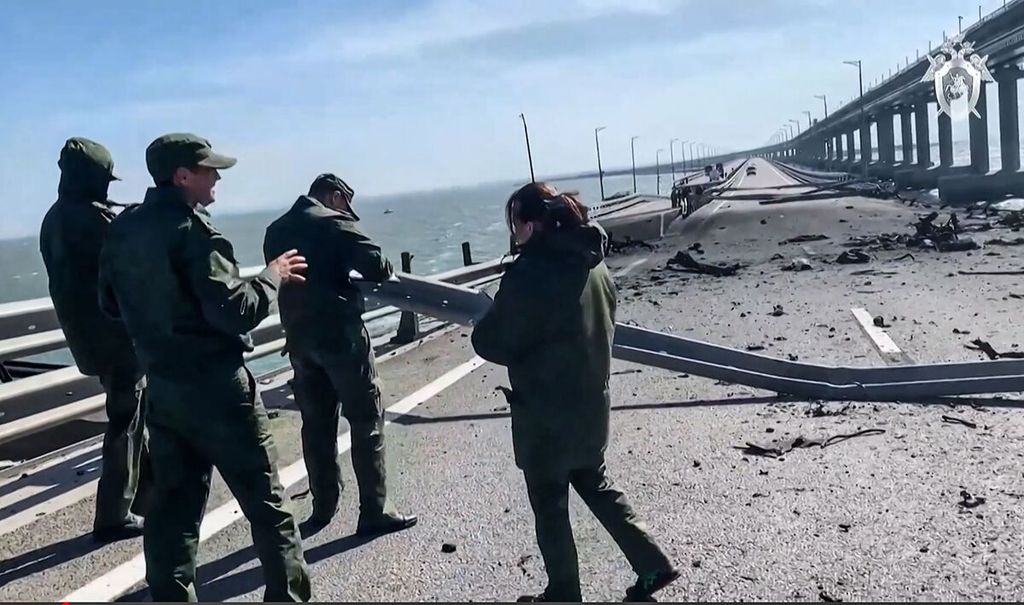 Petugas Komite Investigasi Rusia bekerja mengumpulkan data-data di atas Jembatan Crimea yang ambruk akibat ledakan sebuah truk, Sabtu (8/10/2022). 