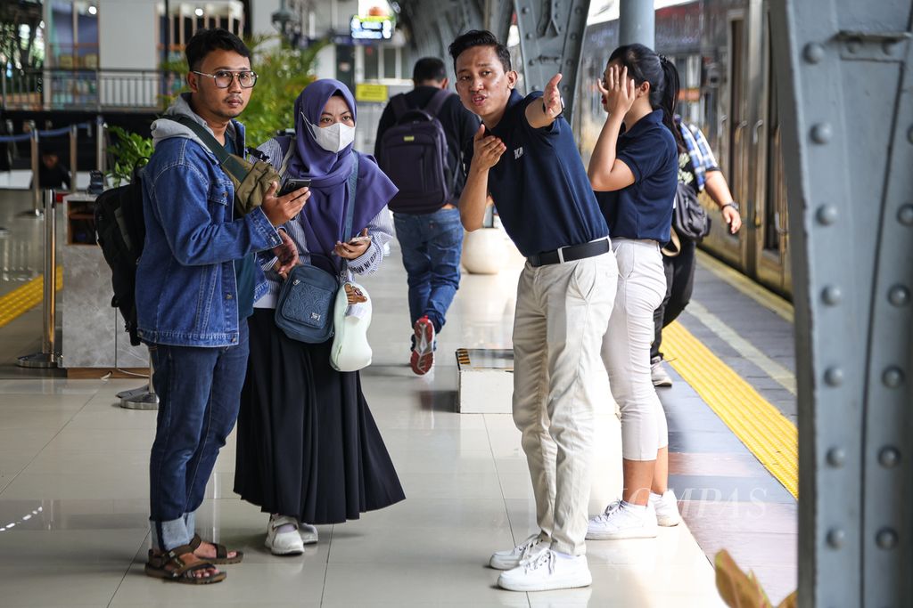 Prama mengarahkan penumpang ke gerbong yang sesuai dengan tiket di Stasiun Pasar Senen, Jakarta, Sabtu (30/3/2024). Sebagian warga Jakarta memilih mudik lebih awal karena kehabisan tiket dan menghindari keramaian saat puncak arus mudik. Menurut survei Kementerian Perhubungan, sebanyak 39,32 juta orang akan mudik menggunakan kereta api. 